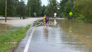 0321 MS couple walking through flood water of flooding river