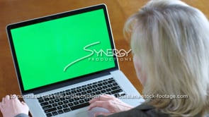 1852 Lady watches video on laptop green screen