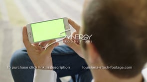1864 young man swiping on smart phone app green screen